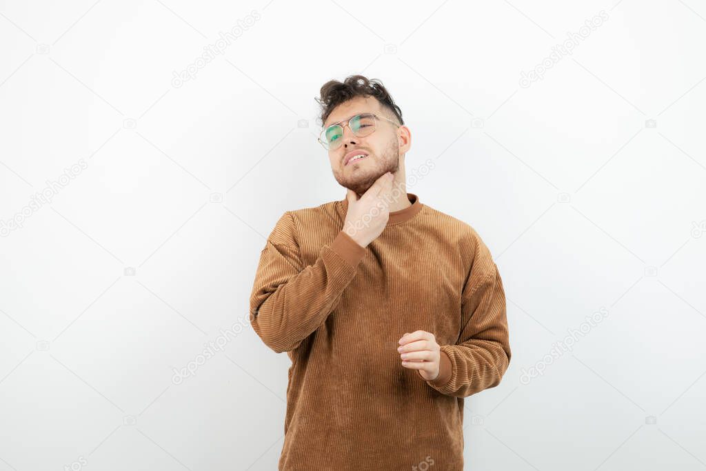 Photo of young man in glasses feeling pain in his throat. High quality photo