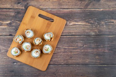 Tahta tahtada somonlu kızarmış suşi ruloları. Yüksek kalite fotoğraf
