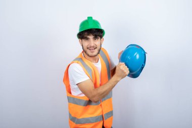 Beyaz arka planda şapkası olan genç bir inşaat işçisi. Yüksek kalite fotoğraf