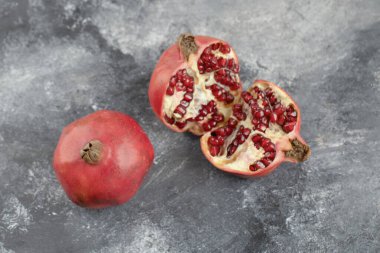 İki tam nar ve arkaplanda dilimlenmiş nar. Yüksek kalite fotoğraf