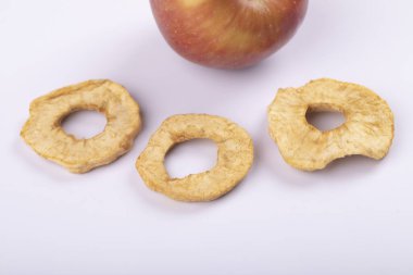 Beyaz yüzeyde kırmızı taze elma ve kurutulmuş elma halkaları. Yüksek kalite fotoğraf