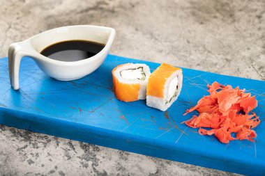 Mavi tahtada iki parça somon balığı ve zencefil. Yüksek kalite fotoğraf