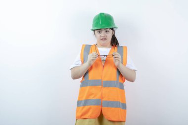 Beyaz duvarda gözlük takan genç bir inşaat işçisi. Yüksek kalite fotoğraf