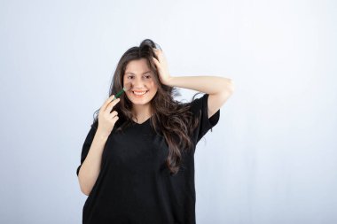 Beyaz arka planda fırçayla allık süren genç ve güzel bir model resmi. Yüksek kalite fotoğraf