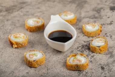 Taş bir masanın üzerine soya soslu taze lezzetli suşi ruloları. Yüksek kalite fotoğraf