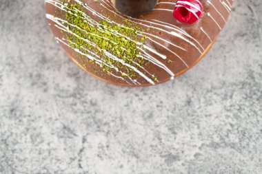 Taş zemine serpiştirilmiş lezzetli çikolata kaplı donut. Yüksek kalite fotoğraf