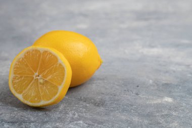 Mermer zemin üzerinde tam ve yarım dilimlenmiş taze limonlar. Yüksek kalite fotoğraf