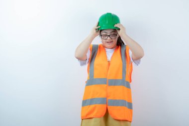 Beyaz duvarda gözlük takan genç bir inşaat işçisi. Yüksek kalite fotoğraf