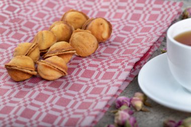Karamelli ceviz şeklinde kurabiyeler ve arka planda bir fincan çay. Yüksek kalite fotoğraf