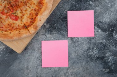 Taş zeminde pembe kağıtları olan lezzetli peynirli pizza. Yüksek kalite fotoğraf