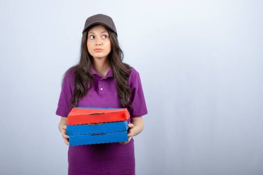 Mor üniformalı, pizza kutularıyla kameraya poz veren güzel teslimatçı kadın. Yüksek kalite fotoğraf