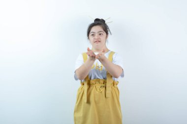 Genç ve güzel kız model ayakta ve beyaz duvara bir öpücük konduruyor. Yüksek kalite fotoğraf