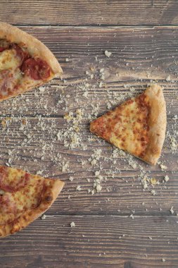 Lezzetli pepperoni ve ahşap masada ekmek kırıntıları olan peynirli pizza. Yüksek kalite fotoğraf