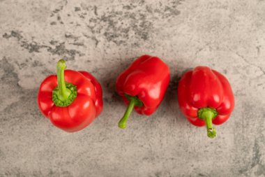 Taş zemine üç tane kırmızı dolma biber. Yüksek kalite fotoğraf