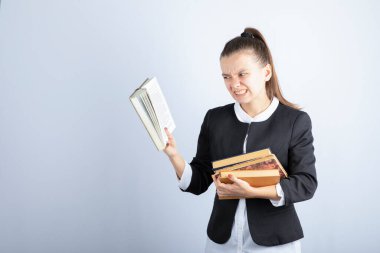 Beyaz arka plan üzerine kitap okuyan bir kız öğrencinin resmi. Yüksek kalite fotoğraf