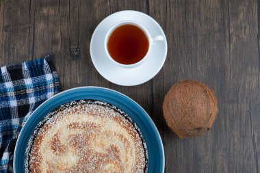 Tahta bir masaya taze hindistan cevizi konmuş bir tabak lezzetli turta. Yüksek kalite fotoğraf