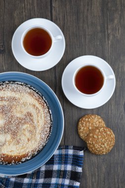 Tahta masaya konmuş turta ve çayla yerleştirilmiş tahıllı yulaf ezmeli kurabiyeler. Yüksek kalite fotoğraf