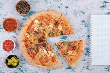 Acı pizza dilimleri, biberli ve biber tozlu mermer arka planda. Yüksek kalite fotoğraf