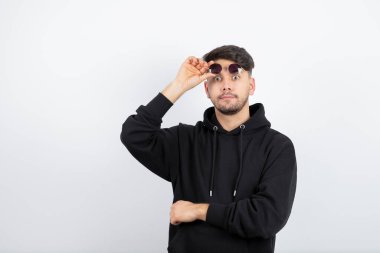 Ayakta duran ve poz veren gözlüklü genç bir adamın portresi. Yüksek kalite fotoğraf