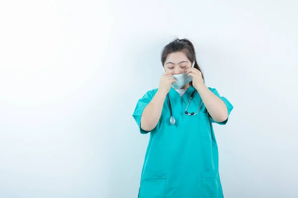 Jovem Enfermeira Com Estetoscópio Vestindo Máscara Facial Médica Contra Parede — Fotografia de Stock