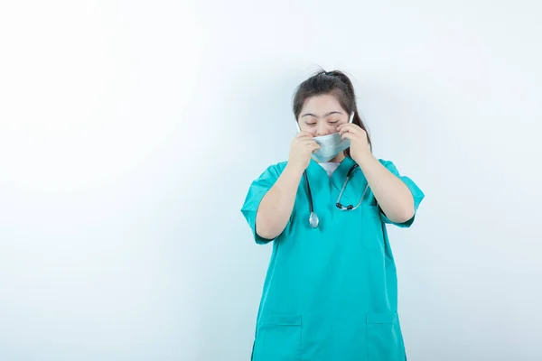 Jonge Vrouwelijke Verpleegster Met Stethoscoop Met Medisch Gezichtsmasker Tegen Witte — Stockfoto