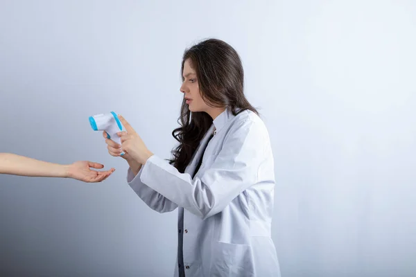 Image of female doctor with thermometer checking someone\'s temperature. High quality photo