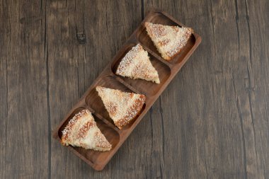 Tahta masa üzerinde hindistan cevizi parçacıkları serpiştirilmiş ahşap pasta dilimleri. Yüksek kalite fotoğraf