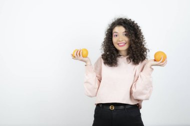 Güzel kıvırcık kız elinde taze portakal meyveleri tutuyor. Yüksek kalite fotoğraf