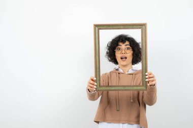 Ahşap çerçevenin ortasında poz veren gözlüklü güzel bir kadın. Yüksek kalite fotoğraf