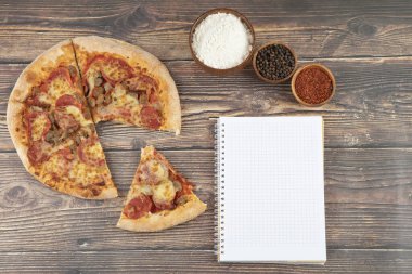 Tahta bir masada dizüstü bilgisayarı olan lezzetli pizza dilimleri. Yüksek kalite fotoğraf