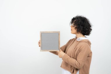 Gözlüklü, içi boş çerçeveli güzel kıvırcık bir kadın resmi. Yüksek kalite fotoğraf