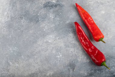 Mermer zemin üzerine iki kırmızı biber yerleştirilmiş. Yüksek kalite fotoğraf