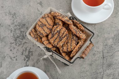 İki fincan siyah çay, içinde bir sepet lezzetli kurabiye ve tohumlar olsun. Yüksek kalite fotoğraf