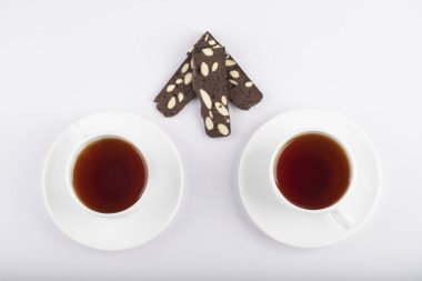 Beyaz masaya dilimlenmiş kek konulmuş beyaz çay fincanları. Yüksek kalite fotoğraf