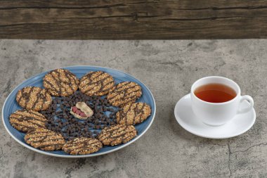 Çikolatalı bisküvi ve mermer arka planda bitki çayı ile mavi tabak. Yüksek kalite fotoğraf