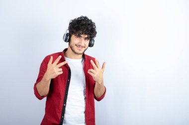 Kulaklıklı genç bir adamın beyaz arka plandaki kameraya baktığı görüntü. Yüksek kalite fotoğraf