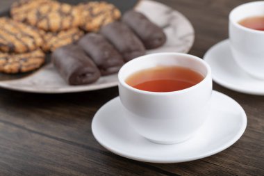 Taş masaya konmuş bir fincan sıcak çayla çeşitli tatlı atıştırmalıklar. Yüksek kalite fotoğraf