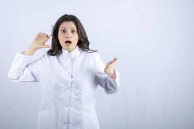Photo of young doctor with syringe feeling pain on white background. High quality photo