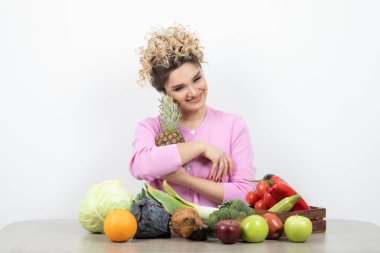 Masada oturan olgun ananaslı güzel genç bir kadın. Yüksek kalite fotoğraf