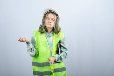 Not defteriyle beyaz duvarın ötesini düşünen güzel bir kadın mühendis resmi. Yüksek kalite fotoğraf