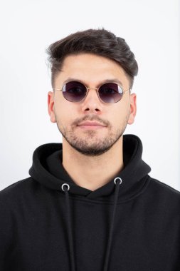 Gözlüklü genç yakışıklı adamın ayakta dikilip baktığı fotoğraf. Yüksek kalite fotoğraf