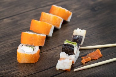 Ahşap zemine yerleştirilmiş taze lezzetli suşi dürümleri. Yüksek kalite fotoğraf