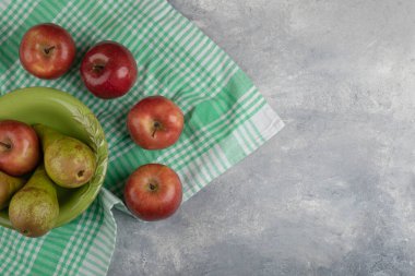 Yeşil kase kırmızı elma ve yeşil armut mermer arka planda. Yüksek kalite fotoğraf