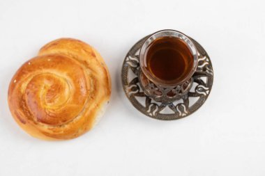 Daire şeklinde hamur işi, beyaz arka planda bir bardak siyah çay. Yüksek kalite fotoğraf