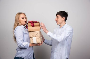 Adam gri duvara karşı sevgilisine Noel hediyeleri veriyor. Yüksek kalite fotoğraf