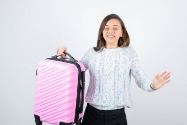 Genç turist resmi pembe bir bavul tutuyor. Yüksek kalite fotoğraf