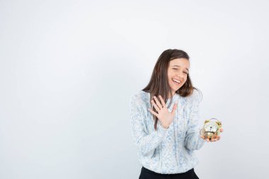 Çalar saat tutan süveterli genç kız portresi. Yüksek kalite fotoğraf