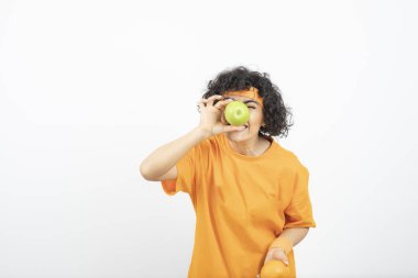 Meyveli genç kadın beyaz arka planda poz veriyor