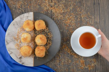 Bir tabak tatlı yuva pastası ve ahşap masada bir fincan çay. Yüksek kalite fotoğraf
