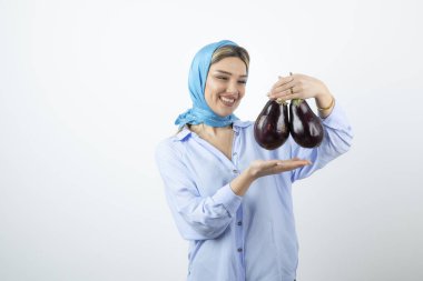 Mendilli, patlıcan tutan sarışın güzel bir kadın resmi. Yüksek kalite fotoğraf